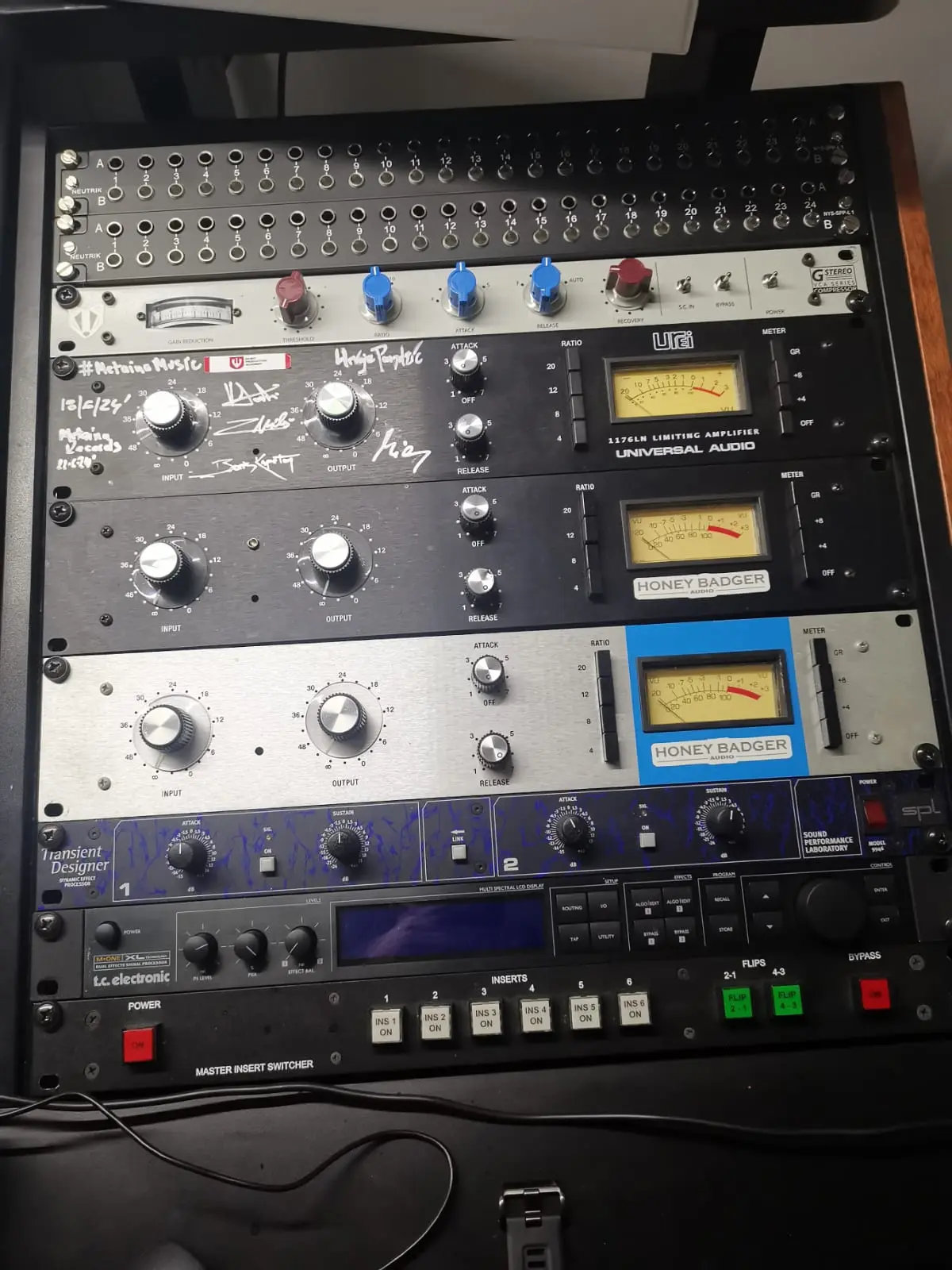 A rack containing several completed 1176-style limiters, including HoneyBadger builds
