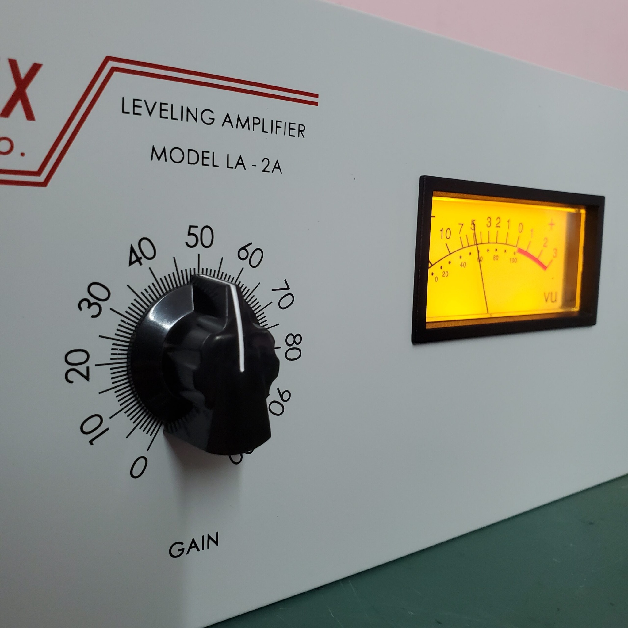 Close detail of an LA-2A front panel, gain control and illuminated VU meter